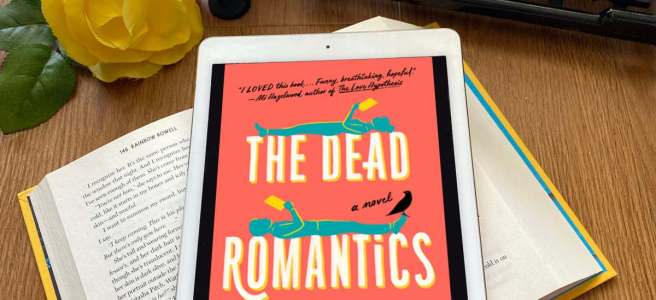 The Dead Romantics book with typewriter, yellow rose, a candle, and a little black crow figuringe